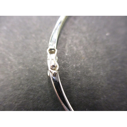 104 - A 9ct white gold bangle set with 3 CZ stones