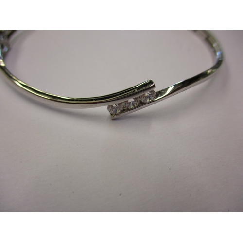 104 - A 9ct white gold bangle set with 3 CZ stones