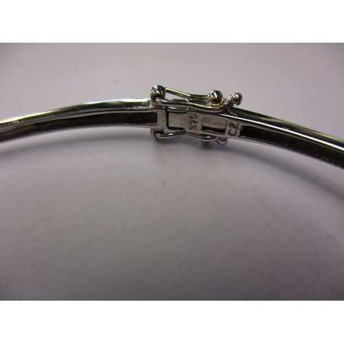 104 - A 9ct white gold bangle set with 3 CZ stones