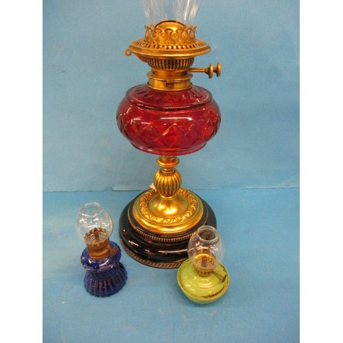 A quantity of antique oil lamps, having glass reservoirs and chimneys