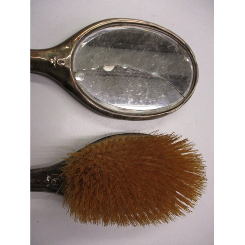 66 - A sterling silver backed mirror and brush, mirror has damage to glass and both have general age-rela... 