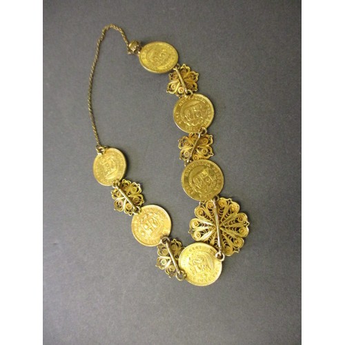 300 - A gold bracelet with filigree panels linking six Peruvian 1/5 Libra gold coins, approx. total weight... 