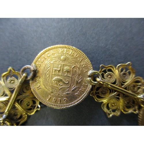 300 - A gold bracelet with filigree panels linking six Peruvian 1/5 Libra gold coins, approx. total weight... 