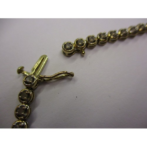 67 - A 9ct yellow gold and diamond tennis bracelet, in good condition with working clasp and general use ... 