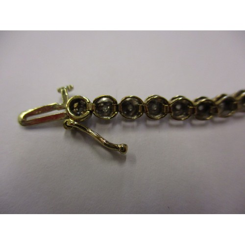 67 - A 9ct yellow gold and diamond tennis bracelet, in good condition with working clasp and general use ... 