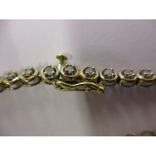 67 - A 9ct yellow gold and diamond tennis bracelet, in good condition with working clasp and general use ... 