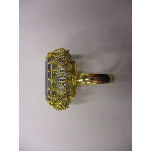 34 - A yellow gold ring marked 18k with a large pale blue topaz? set in a filigree mount, approx. ring si... 