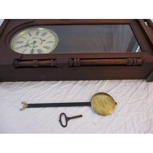 304 - A vintage wood cased wall clock with key and pendulum, runs when wound, approx. length 82cm, in good... 