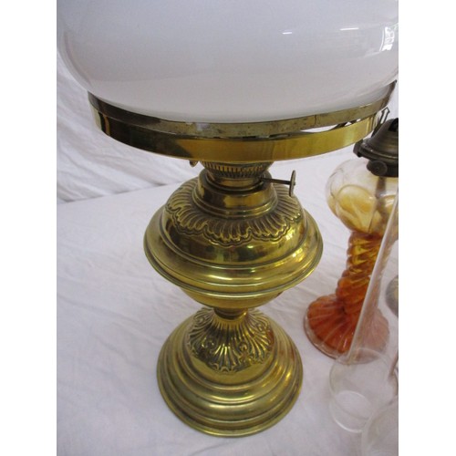 329 - A quantity of vintage oil lamps to include some shades and chimneys