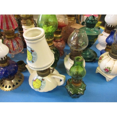 344 - A very large quantity of vintage miniature oil lamps, most having chimneys or shades, all with gener... 