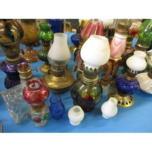 344 - A very large quantity of vintage miniature oil lamps, most having chimneys or shades, all with gener... 