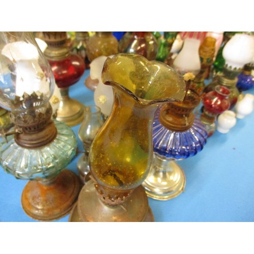 344 - A very large quantity of vintage miniature oil lamps, most having chimneys or shades, all with gener... 