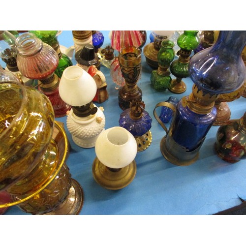 344 - A very large quantity of vintage miniature oil lamps, most having chimneys or shades, all with gener... 