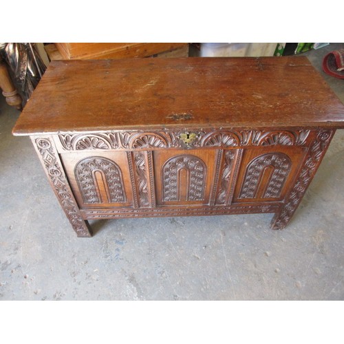 281 - An 18th century oak coffer, of panel construction on style legs and having carved decoration approx.... 