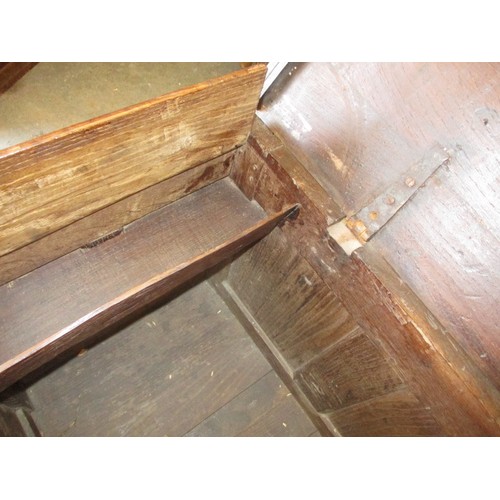 281 - An 18th century oak coffer, of panel construction on style legs and having carved decoration approx.... 