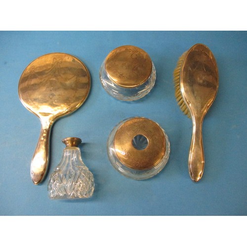 154 - A parcel of silver mounted dressing table items to include jars and a mirror and brush, having some ... 