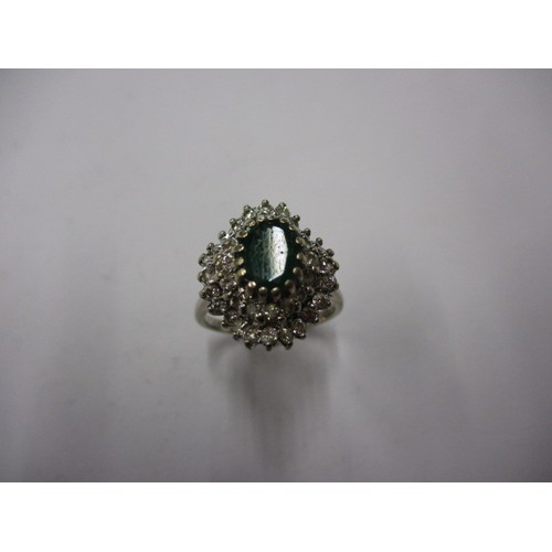4 - An 18ct white gold diamond dress ring, having a green central stone which is in need of a polish, ap... 