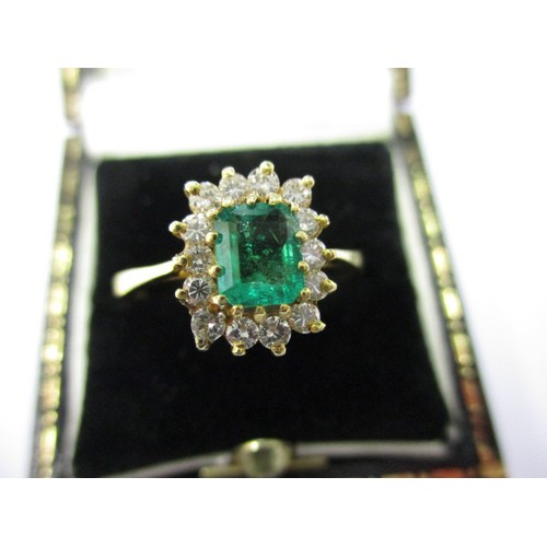 16 - An 18ct yellow gold, diamond and emerald cluster ring, the central rectangular emerald measuring app... 