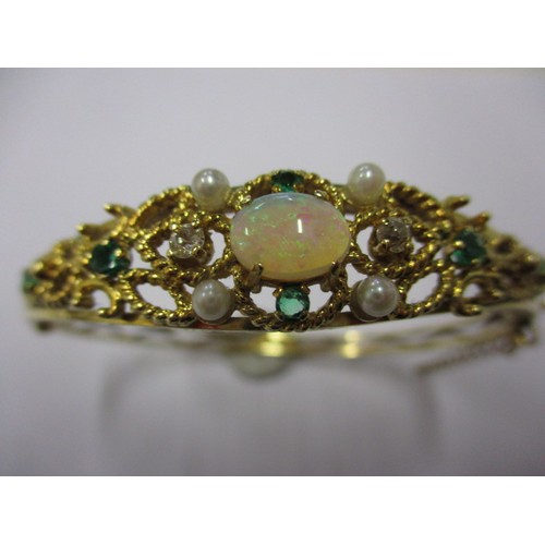 47 - An 18ct gold bangle set with emeralds, diamonds, seed pearls and central opal. Approximate internal ... 