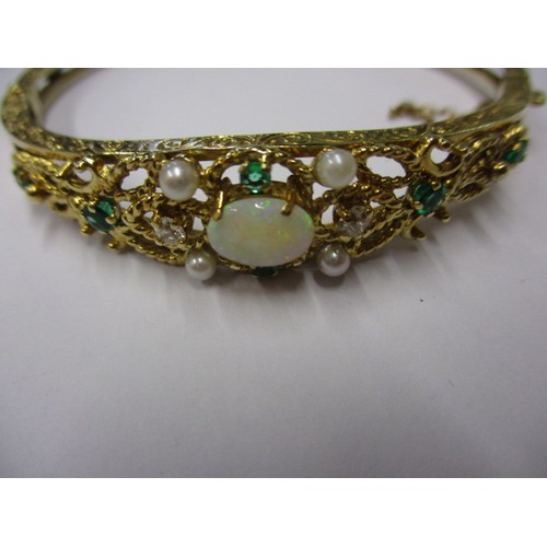 47 - An 18ct gold bangle set with emeralds, diamonds, seed pearls and central opal. Approximate internal ... 