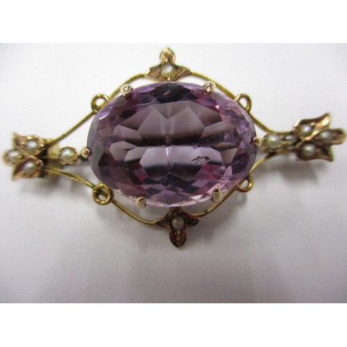 50 - An early 20thC, Art Nouveau 9ct gold brooch, set with seed pearls and large central amethyst colour ... 
