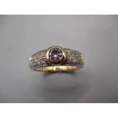 30 - A 9ct yellow gold ring with a central round brilliant cut diamond of approx. 4.2mm diameter, the sho... 