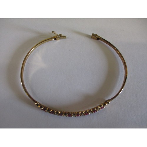 66 - A 9ct yellow gold diamond and ruby bangle, approx. weight 7.9g, approx. diameter 6cm in good pre-own... 