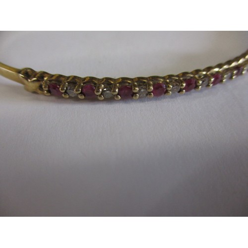 66 - A 9ct yellow gold diamond and ruby bangle, approx. weight 7.9g, approx. diameter 6cm in good pre-own... 