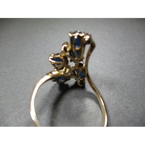 18 - A stylized yellow gold ring set with sapphires and diamonds, approx. ring size ‘P’ having an off-set... 