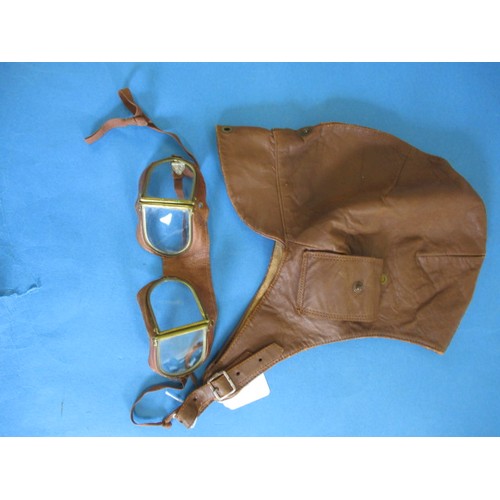 243 - An early 20th century leather driving helmet and goggles and a later silk scarf, the helmet has one ... 