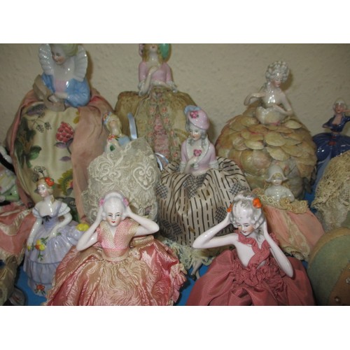 255 - A collection of antique and later porcelain half dolls, some made in to pin cushions and some in to ... 