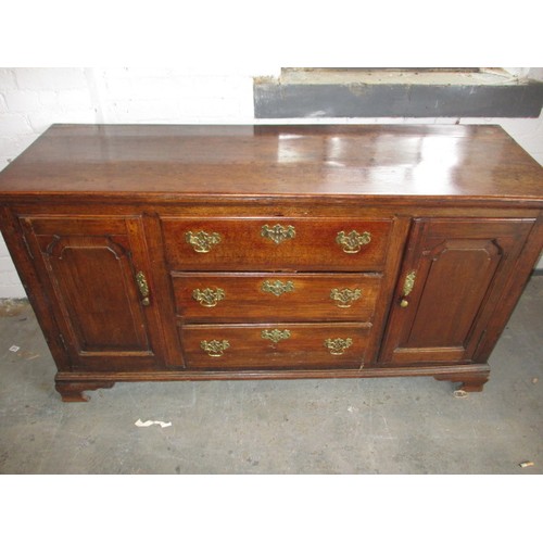 313 - A Georgian oak sideboard with 3 central drawers flanked with cupboards. Dating C mid/late 18th centu... 