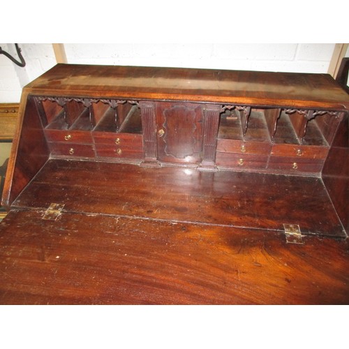 316 - A 19thC Mahogany bureau having 4 long graduated drawers and fold over writing flap, revealing drawer... 