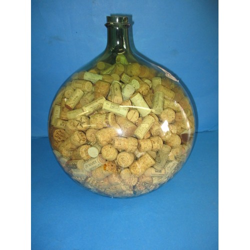 305 - An antique green glass carboy, approx. height 45cm, filled with wine bottle corks, in good condition... 