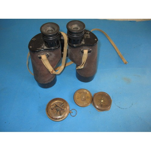 214 - A pair of US navy binoculars marked Bausch & Lomb and two brass compasses, one dated 1904, in used c... 