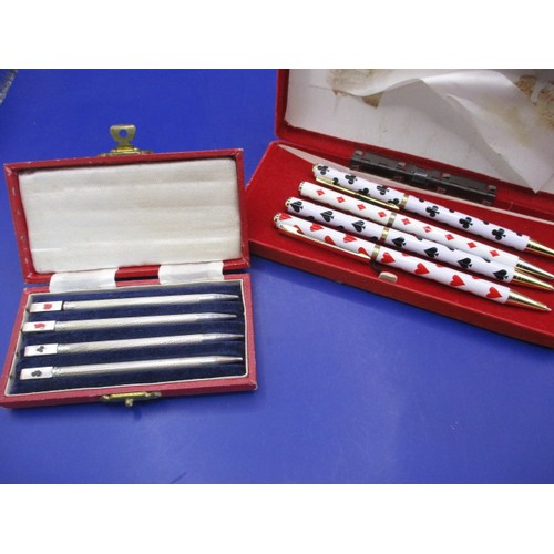 137 - A boxed set of 4 sterling silver propelling pencils, each with card suits to top, some loss to ename... 