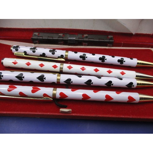 137 - A boxed set of 4 sterling silver propelling pencils, each with card suits to top, some loss to ename... 