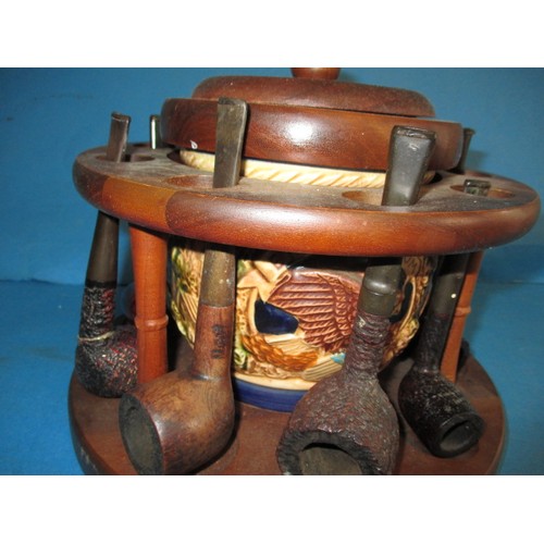 362 - A vintage circular pipe rack with central tobacco jar, pipes include examples by Dunhill and Peterso... 