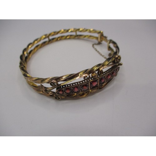 89 - An antique 9ct gold bangle set with a central band of rubies, approx. weight 9.6g in good pre-owned ... 