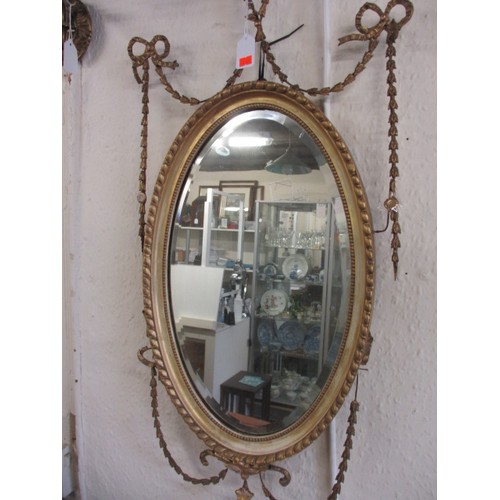 81 - A 19th century gilt framed mirror, the oval panel being bevelled glass, having some age-related dama... 