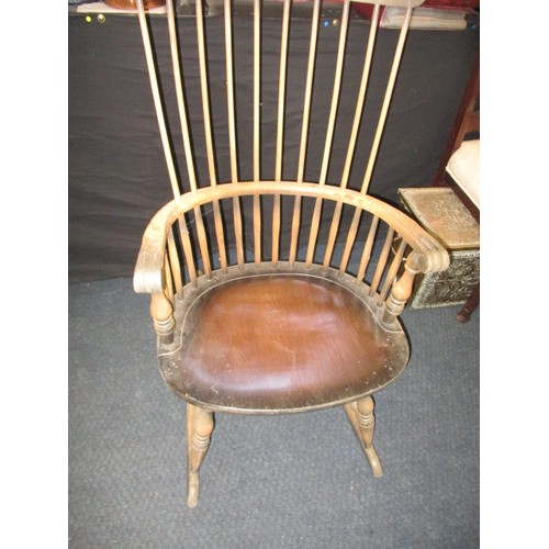 100 - A vintage stick back rocking chair, in well used condition with use-related marks