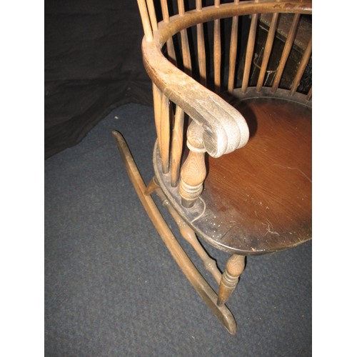 100 - A vintage stick back rocking chair, in well used condition with use-related marks