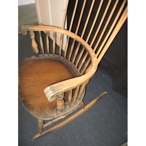 100 - A vintage stick back rocking chair, in well used condition with use-related marks