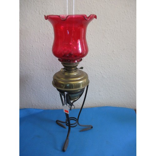 121 - A vintage oil lamp with red glass shade and chimney