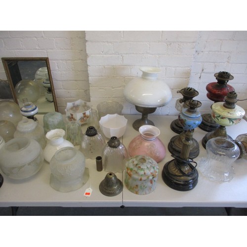 129 - A quantity of oil lamps and parts, to include antique shades, all in used condition