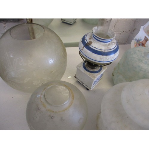 129 - A quantity of oil lamps and parts, to include antique shades, all in used condition