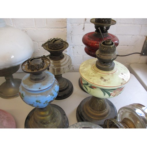 129 - A quantity of oil lamps and parts, to include antique shades, all in used condition