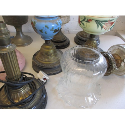 129 - A quantity of oil lamps and parts, to include antique shades, all in used condition