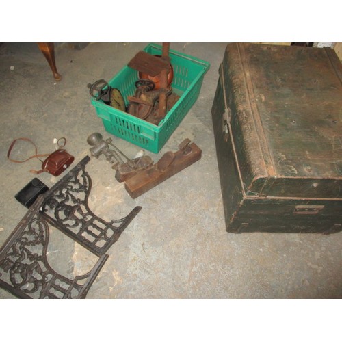 277 - A tin trunk with contents to include a cast iron pillar drill and cast iron brackets