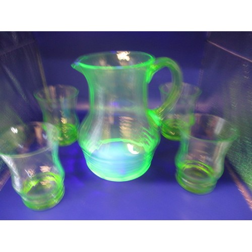 300 - A 1930s uranium glass lemonade set, 4 glasses and a jug, two glasses with small chips to edge